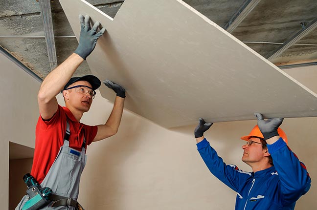 homens-carregando-parede-drywall